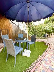 a table and chairs with an umbrella on a yard at Studio Room Central in Chişinău +5 photos