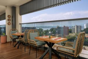 a dining room with a table and chairs and a large window at Four Points by Sheraton Kinshasa in Kinshasa