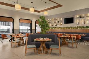 a restaurant with tables and chairs and a tv at Four Points by Sheraton Kinshasa in Kinshasa