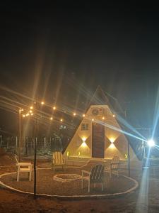 a small house with chairs in front of it at night at Chalé serra da formiga in Riachuelo