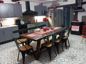 a kitchen with a wooden table and chairs in it at La Gerbaudiere Chambres&Table d hotes proche Mont Saint Michel CUISINE MAISON in Notre-Dame-du-Touchet