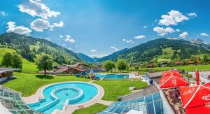 a resort with a pool and mountains in the background at Chalet Franzi - Ruhiges Chalet mit Bergblick, Garten und gratis Eintritt ins Solarbad in Dorfgastein