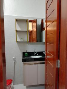 a bathroom with a sink and a mirror at Residencial Ibiapaba in Camocim
