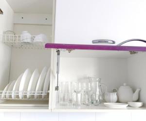a kitchen shelf with dishes and glasses on it at Nectar Apartments in Aktobe +4 photos