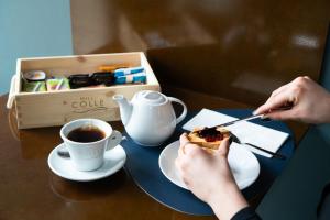 a person eating a piece of cake and a cup of coffee at HILL COLLE - camere & bistrot in Erbusco