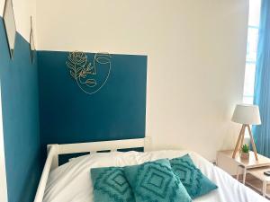 a bedroom with a bed with a blue wall at Le Blue- hyper centre ville in Sens +4 photos