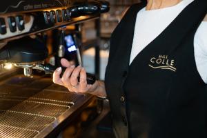 a woman in a kitchen holding a bottle of wine at HILL COLLE - camere & bistrot in Erbusco