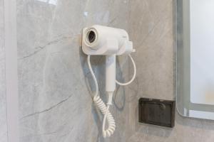 a white phone on a wall in a bathroom at Aqua Soul de Pakbara in Ban Pak Ba Ra