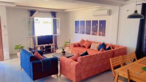 a living room with two couches and a table at Villa bleu azur in Djerba