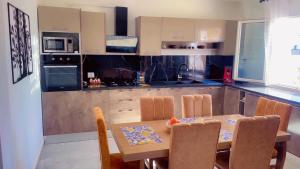 a kitchen with a table and chairs and a table and a kitchen at Villa bleu azur in Djerba
