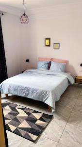 a bedroom with a bed with blue sheets and a rug at Villa bleu azur in Djerba +26 photos
