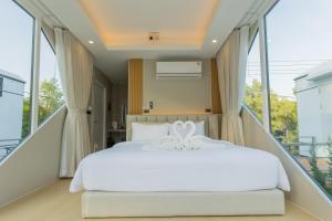 a bedroom with a white bed and large windows at Aqua Soul de Pakbara in Ban Pak Ba Ra +20 photos