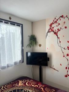 a bedroom with a tv and a tree painted on the wall at Le grand Large in Arcachon