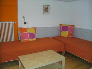 a room with two beds with pillows and a table at Gästehaus Futterer in Teningen