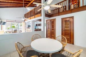 a dining room with a white table and chairs at Caribbean Villas Hotel in San Pedro