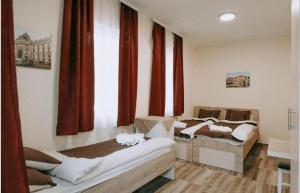 two beds in a room with red curtains at Evropa Sombor in Sombor