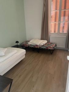 a room with two beds and a table and a window at Le Billeron in Saint-Amand-Montrond