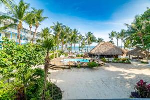an image of a resort with a pool and palm trees at Caribbean Villas Hotel in San Pedro