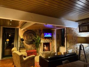 a living room with a stone wall with a fireplace at Quinta Santo Antonio do Rio in Celorico da Beira