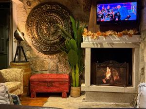 a living room with a fireplace and a tv at Quinta Santo Antonio do Rio in Celorico da Beira