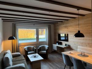 a living room with a couch and a table and a tv at Hardthof Sauerland in Schmallenberg