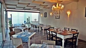 uma sala de jantar com mesas e cadeiras e um lustre em Scilla Maris Charming Suites em Marzamemi