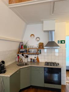 a kitchen with a stove and a sink at At Loum in Alkmaar