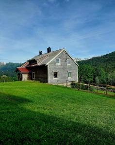 a house sitting on top of a green field at Llama Lodge Authentic Sunnfjord Farm in Kleivane