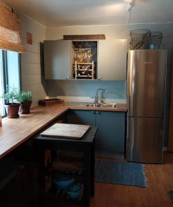 a kitchen with a stainless steel refrigerator and a sink at Llama Lodge Authentic Sunnfjord Farm in Kleivane