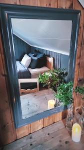 a mirror reflecting a bedroom with a bed in a room at Llama Lodge Authentic Sunnfjord Farm in Kleivane