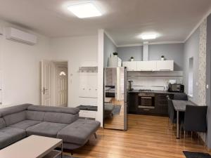 a living room with a couch and a kitchen at BE-LE-VALÓ APARTMAN in Szécsény
