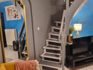 a staircase in a living room with a mirror at Lodge Beauty & Roger in Chièvres