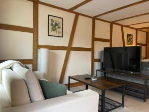 a living room with a white couch and a tv at Studio with Kitchen & Parking near Thun and Bern in Herbligen 