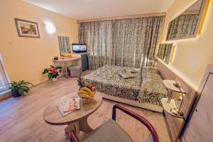 a living room with a bed and a table in a room at Supreme Victoria in Varna City