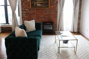 a living room with a green couch and a coffee table at The Luxe Building- 2 Bedroom Apartment in Metropolis in Metropolis +49 photos