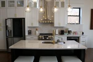 a kitchen with white cabinets and a kitchen island with a sink at The Luxe Building- 2 Bedroom Apartment in Metropolis in Metropolis