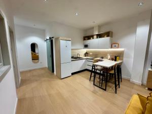 a kitchen with white appliances and a table and chairs at CAROLINA CENTRO SUITEs in Monesterio +24 photos