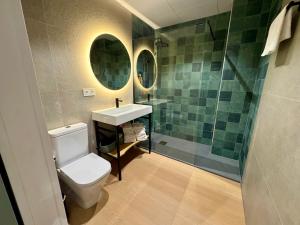 a bathroom with a toilet and a sink and a shower at CAROLINA CENTRO SUITEs in Monesterio