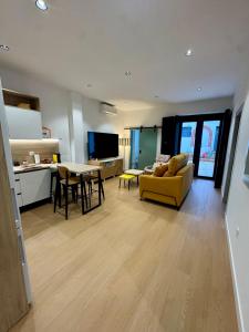 a living room with a yellow couch and a table at CAROLINA CENTRO SUITEs in Monesterio