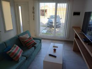 a living room with a green couch and a television at Duplex De Los Padres in Playa Unión