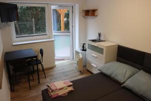 a living room with a couch and a desk and a window at Minuta do plaży - Sarbinowo in Sarbinowo