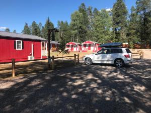 a car parked in front of a row of red buildings at The Red Station Apartment #1 in Columbia Falls