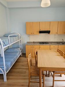 a kitchen with a table and a bunk bed at Residenza Laura Casa Vacanze Capo Vaticano in Capo Vaticano