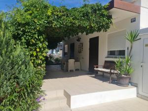 a patio with a bench and plants in front of a house at Studio Sofia in Novalja
