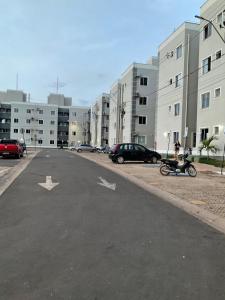an empty parking lot with cars parked in front of buildings at Ap com 2 quartos climatizados , com fechadura eletrônica, WI-FI ,condomínio Village do bosque 3 in Imperatriz