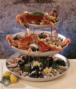 a three tiered plate of food with seafood and vegetables at Le face mer in Le Portel