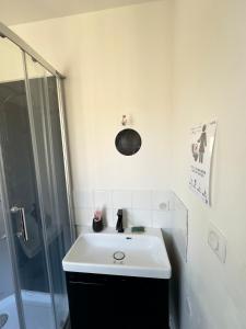 a white bathroom with a sink and a shower at petit studio atypique in Graulhet