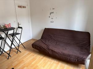 a brown couch in a living room with a table at petit studio atypique in Graulhet +1 photo