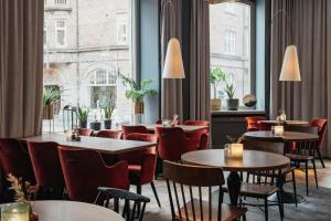 a restaurant with tables and chairs and a large window at Home Hotel Temperance in Malmö