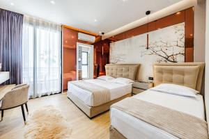 a bedroom with two beds and a table and chairs at Villa Verona in Durrës